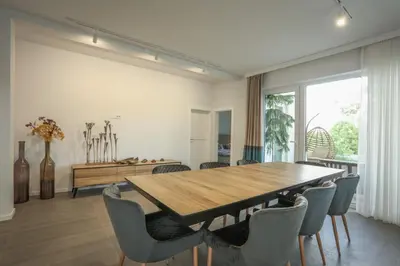 a dining room with a wooden table and chairs at Apartmani Freedom place in Jagodina