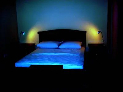 a bedroom with a bed with blue lights on it at HOTEL VILA MITIC LUXX SPA centar in Leskovac