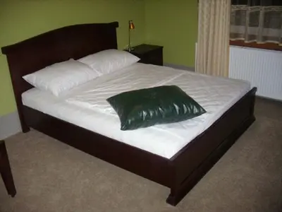 a bed with a green pillow on top of it at HOTEL VILA MITIC LUXX SPA centar in Leskovac