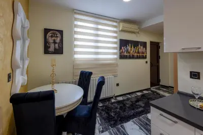 a kitchen with a table and chairs and a window at Andjela Lux in Vrnjačka Banja