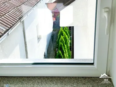 a window view of a garden from a balcony at J&S Apartments - Gornja Toponica in Gornja Toponica