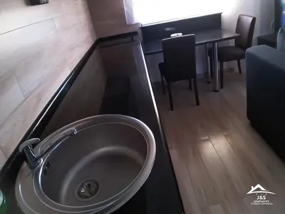 a bathroom with a sink and a table with chairs at J&S Apartments - Gornja Toponica in Gornja Toponica