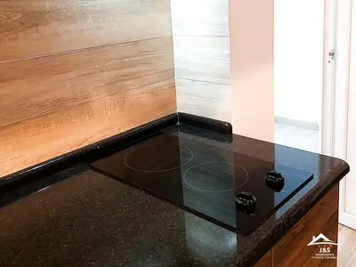 a black counter top in a room with a wooden wall at J&S Apartments - Gornja Toponica in Gornja Toponica