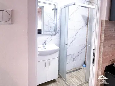 a bathroom with a white sink and a shower at J&S Apartments - Gornja Toponica in Gornja Toponica