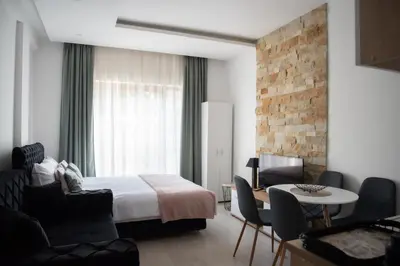 a hotel room with a bed and a table and chairs at Milmari Nlux 74 in Kopaonik
