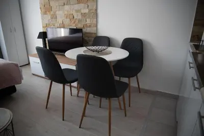 four black chairs around a white table in a room at Milmari Nlux 74 in Kopaonik