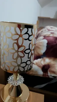 a lamp on a table next to a bed at Zlatna iskra in Ruđinci