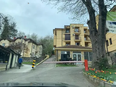 a person walking down a street in front of a building at Apartman Stivi Deluxs 2 in Vrnjačka Banja