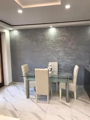 a dining room with a table and chairs and a wall at Apartman Stivi Deluxs 2 in Vrnjačka Banja