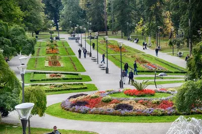 people walking in a park with flowers and lights at Apartman Stivi Deluxs 2 in Vrnjačka Banja
