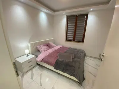 a small bedroom with a pink bed and a window at Apartman Stivi Deluxs 2 in Vrnjačka Banja