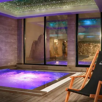 a pool in a room with a window with purple lights at RELAX MILMARI-kopaonik in Kopaonik