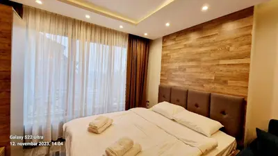 a bedroom with a bed with a wooden wall at RELAX MILMARI-kopaonik in Kopaonik