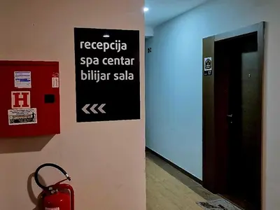 a sign on a wall with a red bag next to a elevator at RELAX MILMARI-kopaonik in Kopaonik