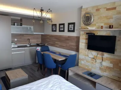a kitchen with a table and blue chairs in a room at RELAX MILMARI-kopaonik in Kopaonik