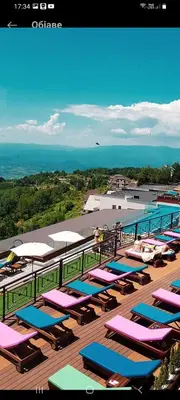 a group of lounge chairs and umbrellas on a deck at RELAX MILMARI-kopaonik in Kopaonik