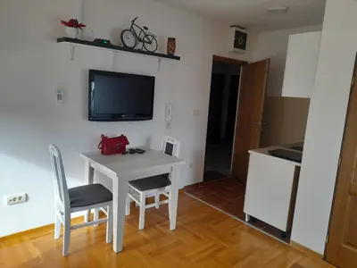 a room with a table and two chairs and a tv at Apartman Ilic in Vrnjačka Banja