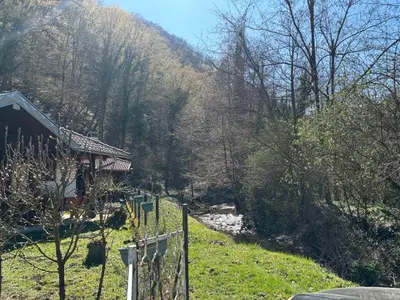 a house with a fence next to a river at Vitez Koja in Vrnjačka Banja