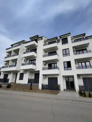 a white apartment building with windows on a street at Apartman Ida in Soko Banja