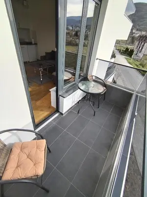 a balcony with chairs and a table on a building at Apartman Ida in Soko Banja