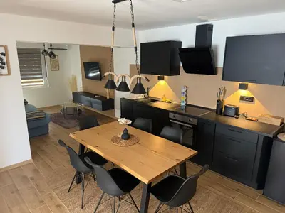 a living room with a wooden table and chairs at Hestia Suite in Zaječar