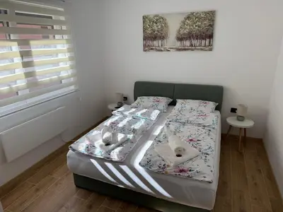 a small bedroom with a bed with two dogs on it at Hestia Suite in Zaječar