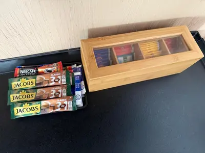 a wooden book shelf next to a pile of books at Hestia Suite in Zaječar