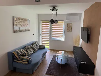 a living room with a blue couch and a table at Hestia Suite in Zaječar