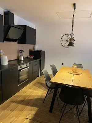a kitchen with a wooden table and chairs in a room at Hestia Suite in Zaječar