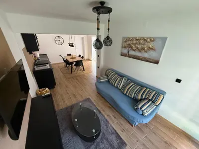 a living room with a blue couch and a table at Hestia Suite in Zaječar