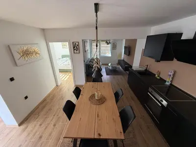a living room with a wooden table and chairs at Hestia Suite in Zaječar