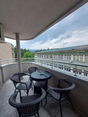 a patio with chairs and tables on a balcony at Apartmani Bojković in Vrnjačka Banja