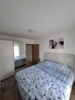a bedroom with a bed with a blue and white comforter at Apartmani Bojković in Vrnjačka Banja