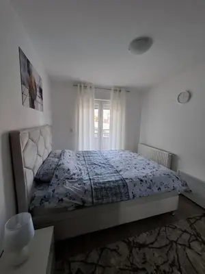 a bedroom with a bed with a blue comforter at Apartmani Bojković in Vrnjačka Banja