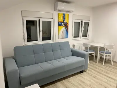 a living room with a blue couch and a table at Apartman MIMI in Vrnjačka Banja