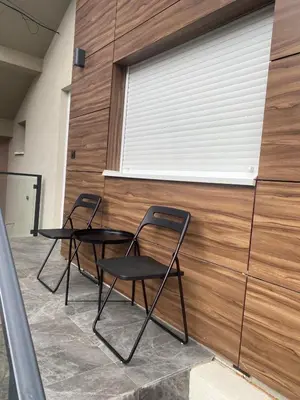 two chairs in front of a wall with a window at Apartman MIMI in Vrnjačka Banja