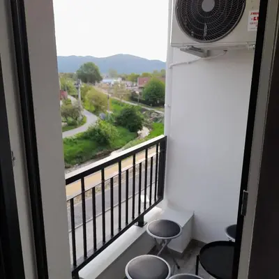 a room with a balcony with stools and a fan at Apartman Ignjatović in Vrnjačka Banja