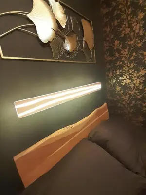 a bedroom with a bed with a light on the wall at Vrnjačka Promenada - Pešačka zona - Baby friendly in Vrnjačka Banja
