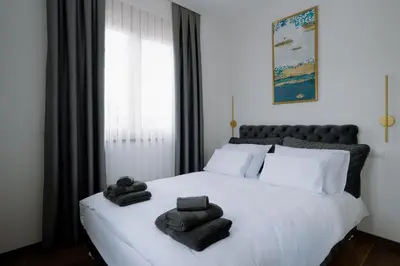 a bedroom with a white bed with towels on it at Terra Apartments in Vrnjačka Banja