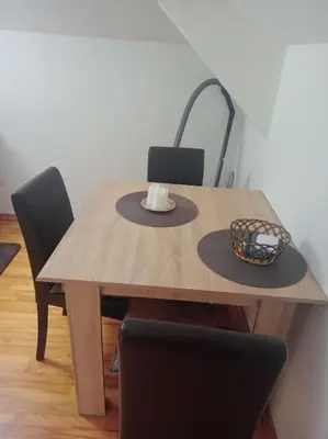 a wooden table with chairs and a bowl on it at Apartman Dačić in Vrnjačka Banja