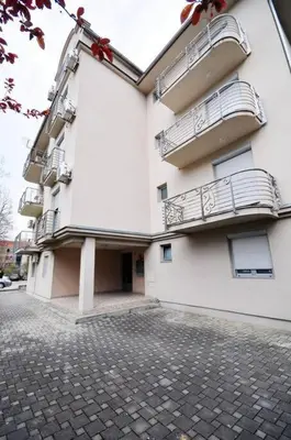 a white building with balconies on the side of it at Apartman Dačić in Vrnjačka Banja