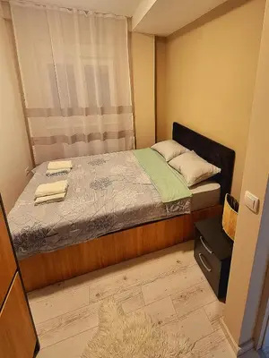 a small bedroom with a bed and a window at Apartman Rojal Vranje in Vranje