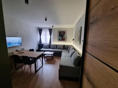 a living room with a couch and a table at AURORA Bela reka C117, Brzeće in Brzeće