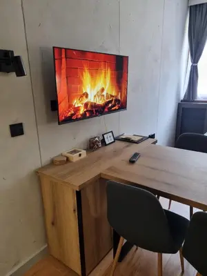 a fireplace in the corner of a room with a table and chairs at AURORA Bela reka C117, Brzeće in Brzeće