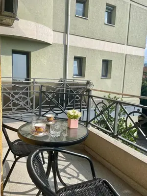 a table and chairs on a balcony with a building at Apartman Marija in Vrnjačka Banja