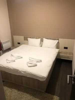 a bed with white sheets and towels on it at Apartman na Kopaoniku in Kopaonik