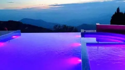 a swimming pool with purple lights and a cross on it at Apartman na Kopaoniku in Kopaonik