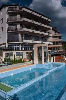 a building with a swimming pool in front of a building at Apartman na Kopaoniku in Kopaonik
