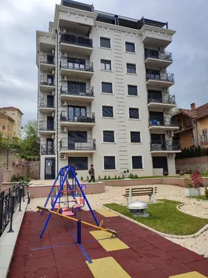 a playground in front of a large apartment building at Apartman Desanka in Vrnjačka Banja