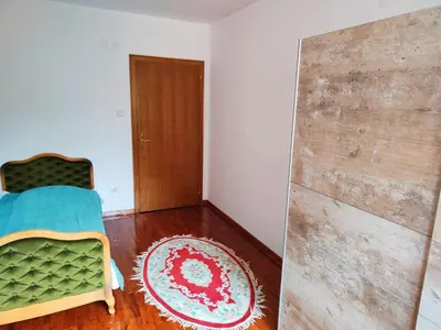a bedroom with a bed and a wooden door at Apartman 5ra in Vrnjačka Banja